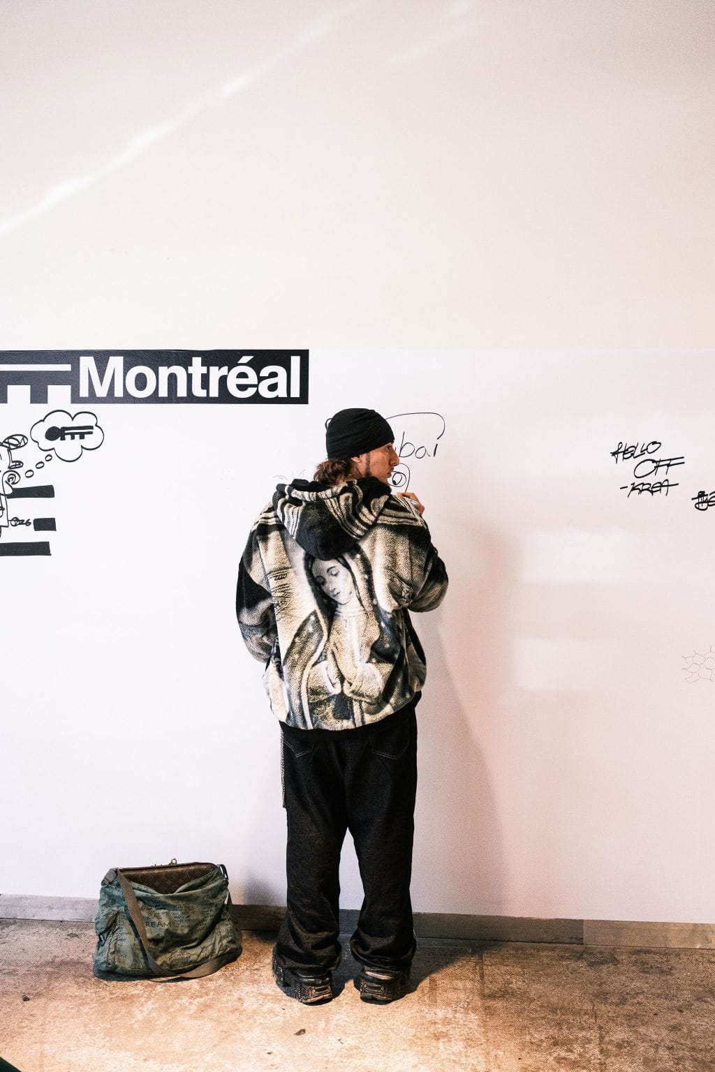 Artist drawing on an OFFF Montréal wall during the 2026 festival